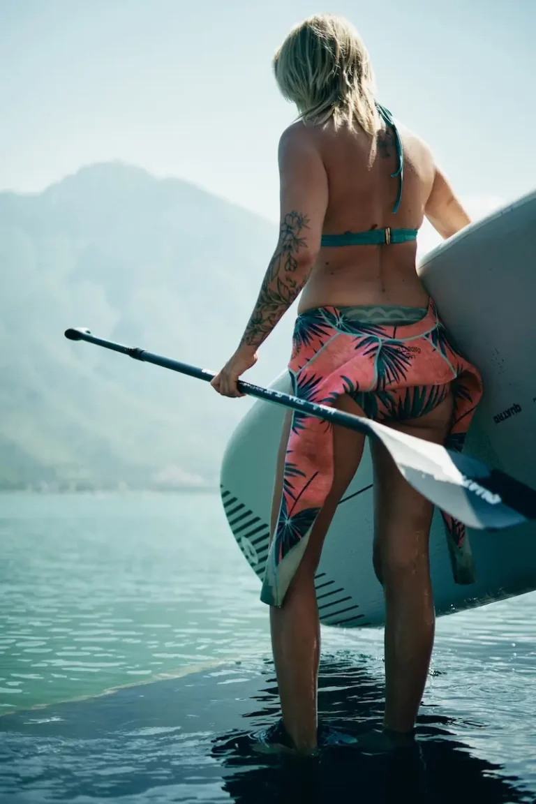 blonde women going in to Lake Garda with a SUP board