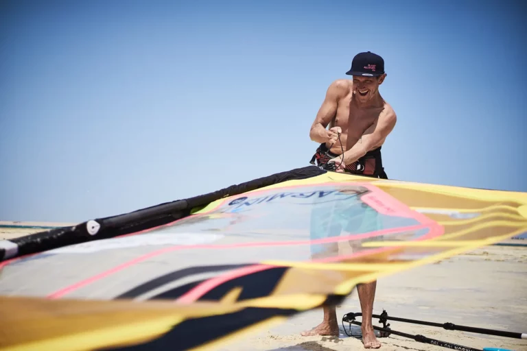 surfer rigging up sail