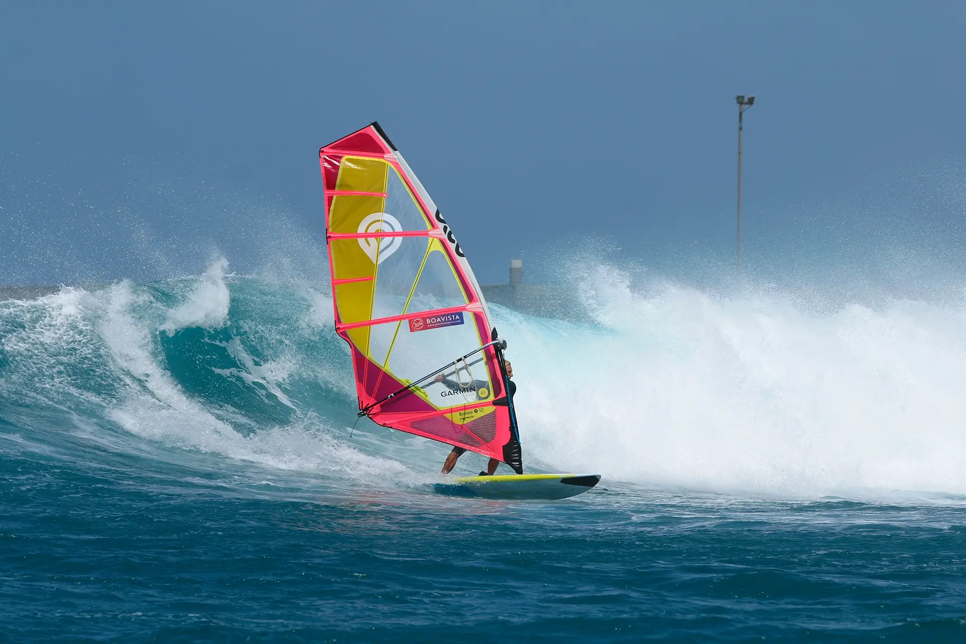 Windsurfer with pink sail in a wave at Boavista