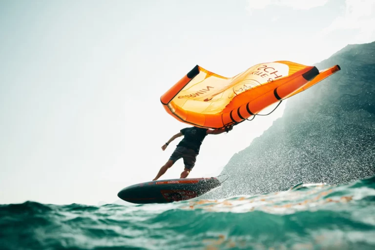 wingfoiler at Lake Garda with orange wing surfing waves