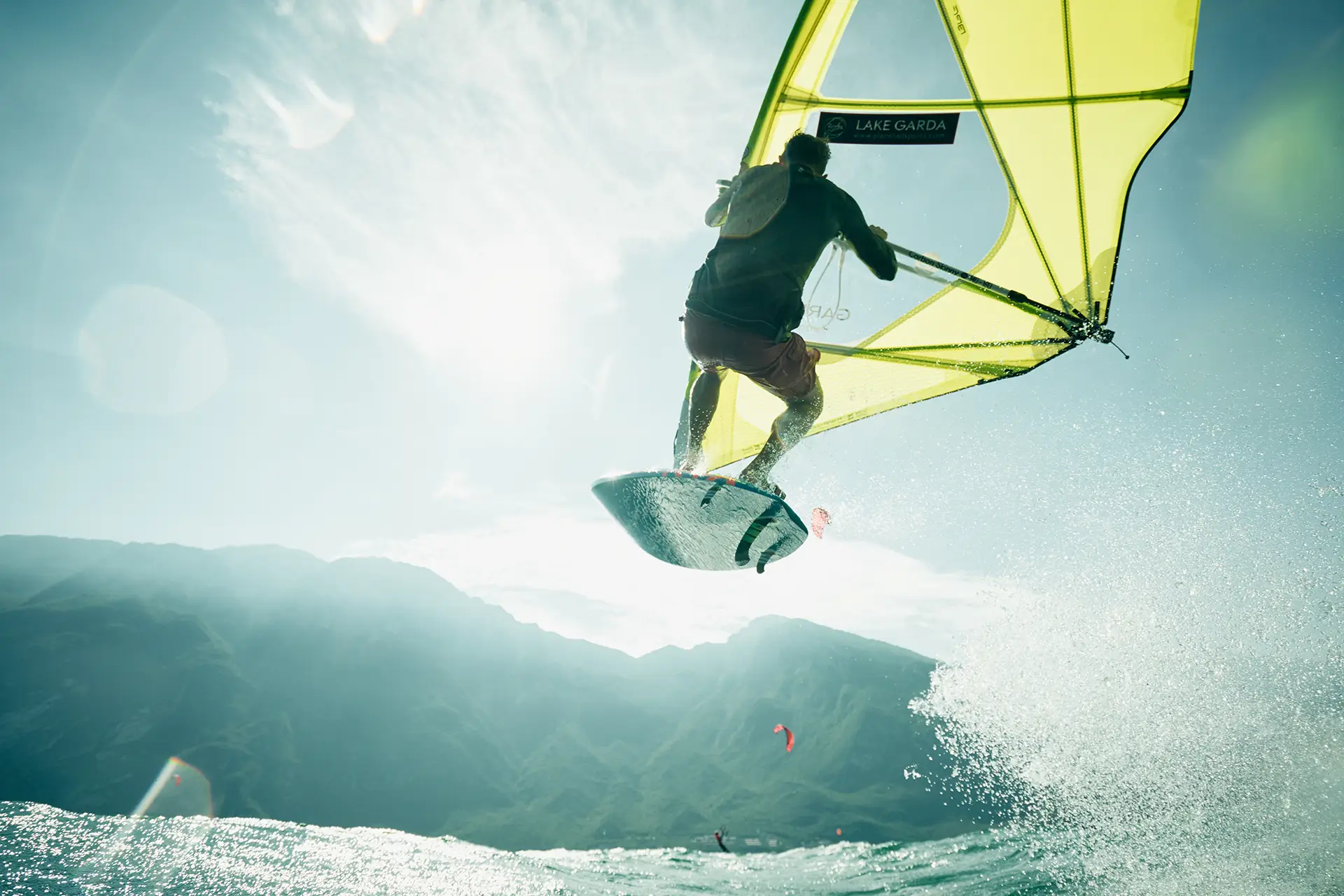 windsurfer jumps at Lake Garda in backlight