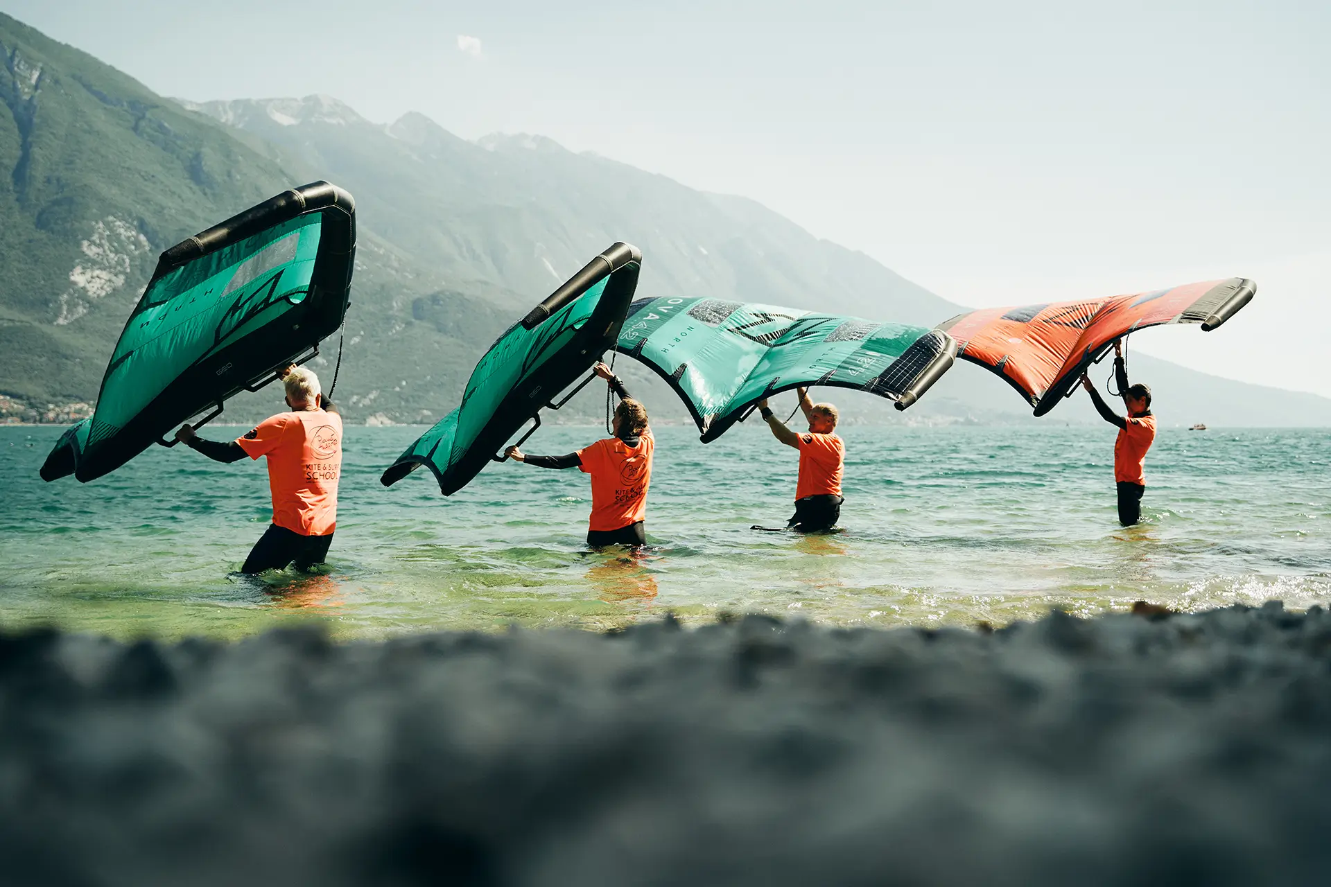 four wingfoil students practice in shallow water at Lake Garda