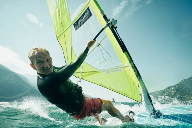 Felix Quadfaß Windsurft am Gardasee mit gelbem Segel und blauem Board wasser spritzt
