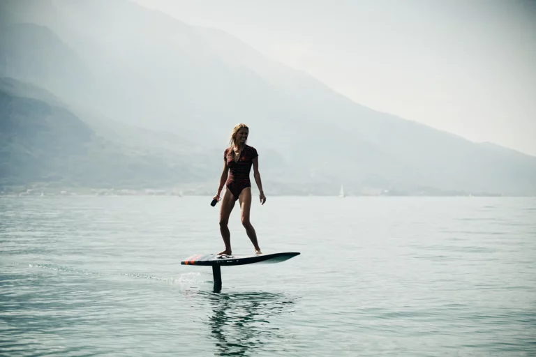 blonde women flying with Audi e-tron foil board over Lake Garda