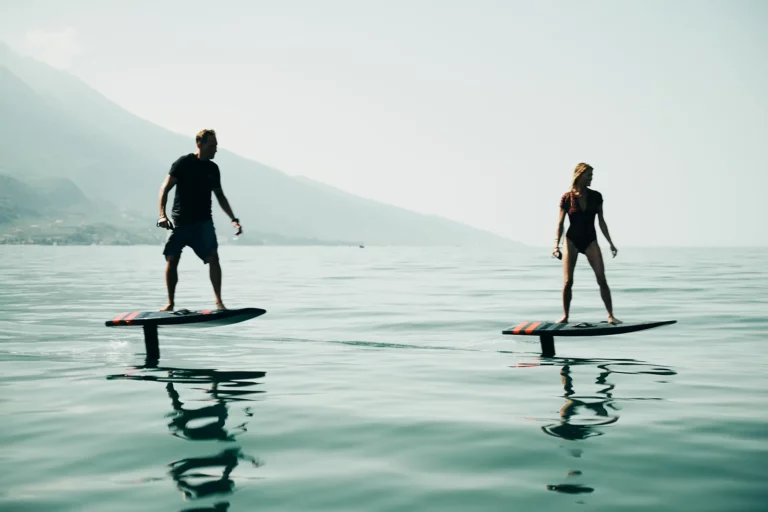 Mann und Frau fahren mit e-foil über den Gardasee