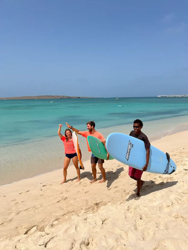 Drei Surfer am Strand
