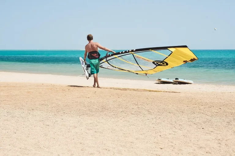 Felix Quadfass windsurfer walks over beach in to the water