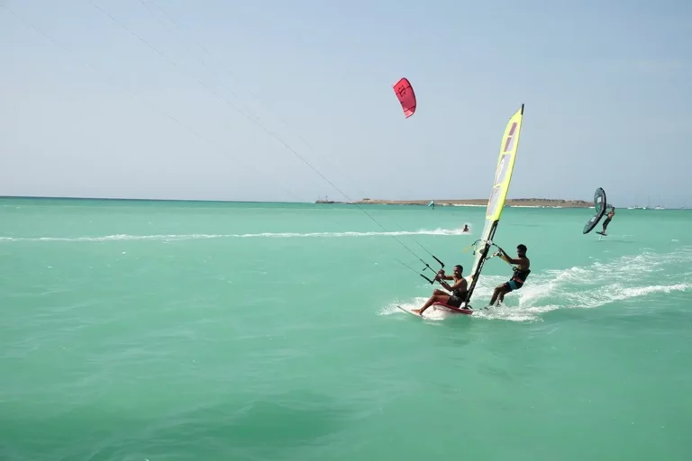Kiter und Windsurfer gleiten zusammen über türkises Wasser