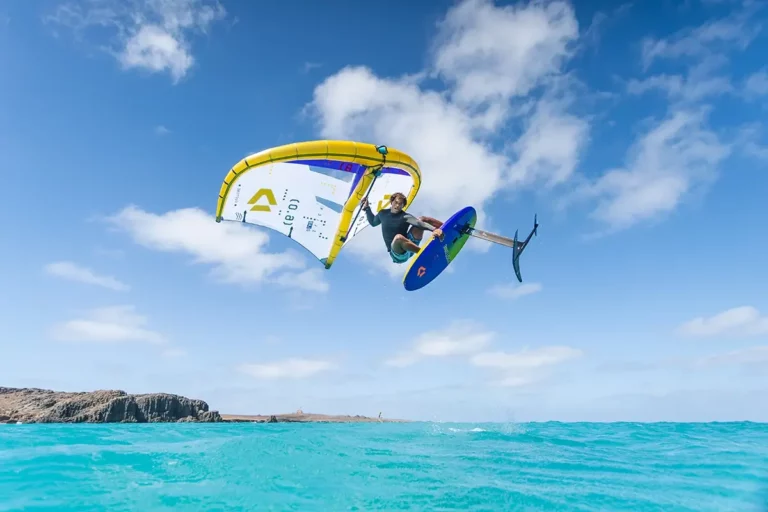 Wingfoil profi Wesley Brito mit Duotone Wing weiss und gelb springt bei türkisem Wasser Kapverden
