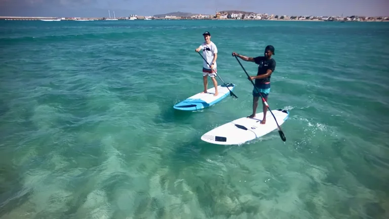 Zwei Stand-Up-Paddler paddeln über türkises Wasser auf Boavista